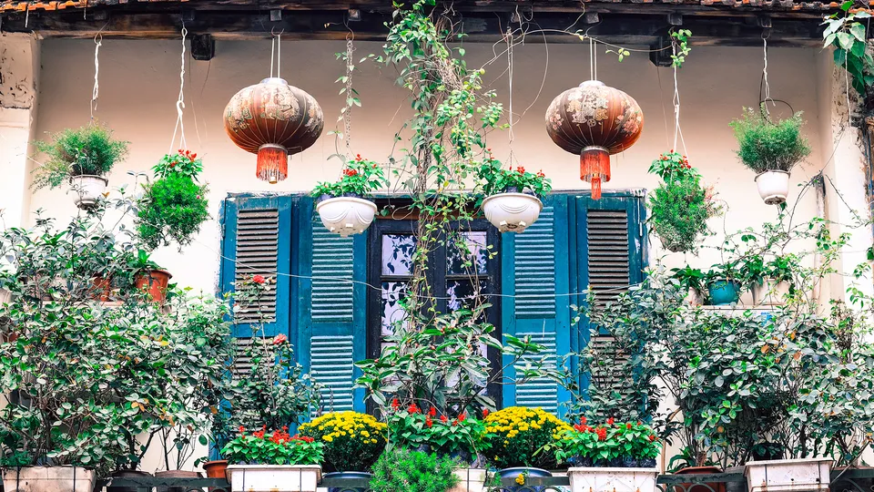 Finestra con fiori e lanterne nel Quartiere Vecchio di Hanoi