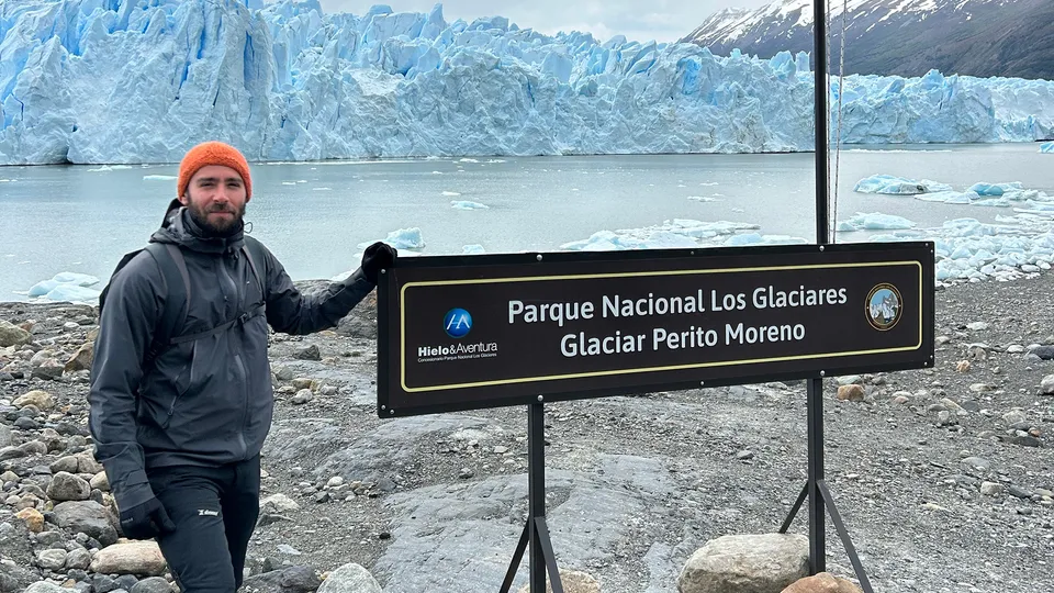 Uomo vicino al cartello di ingresso al Parco Nazionale Los Glaciares